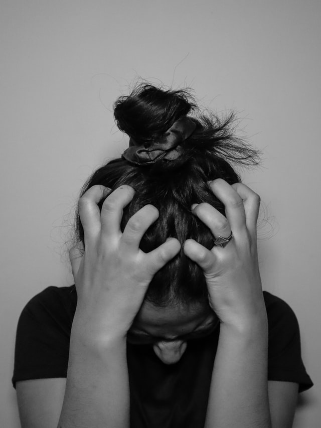 A woman grabbing her head.